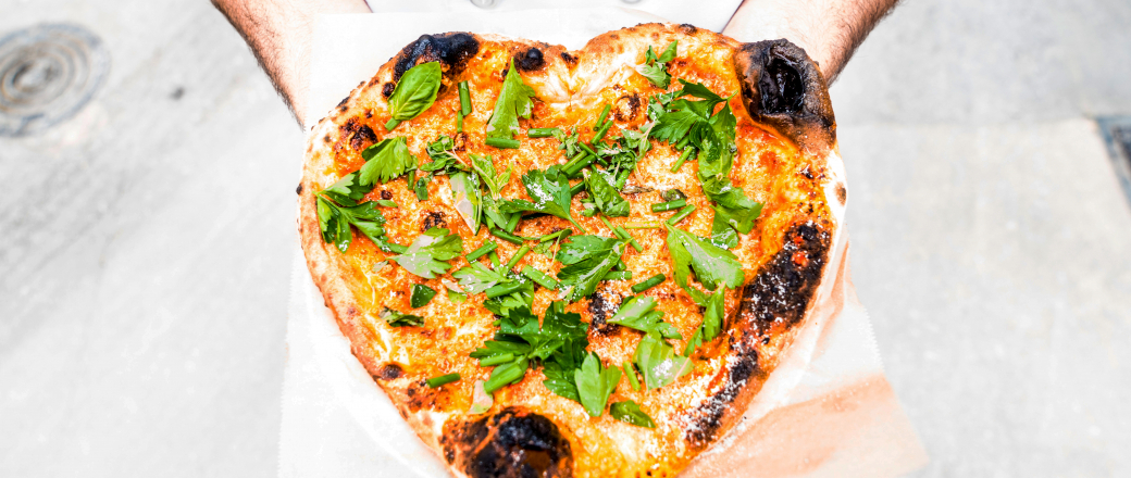 Heart shaped pizza with cheese and basil